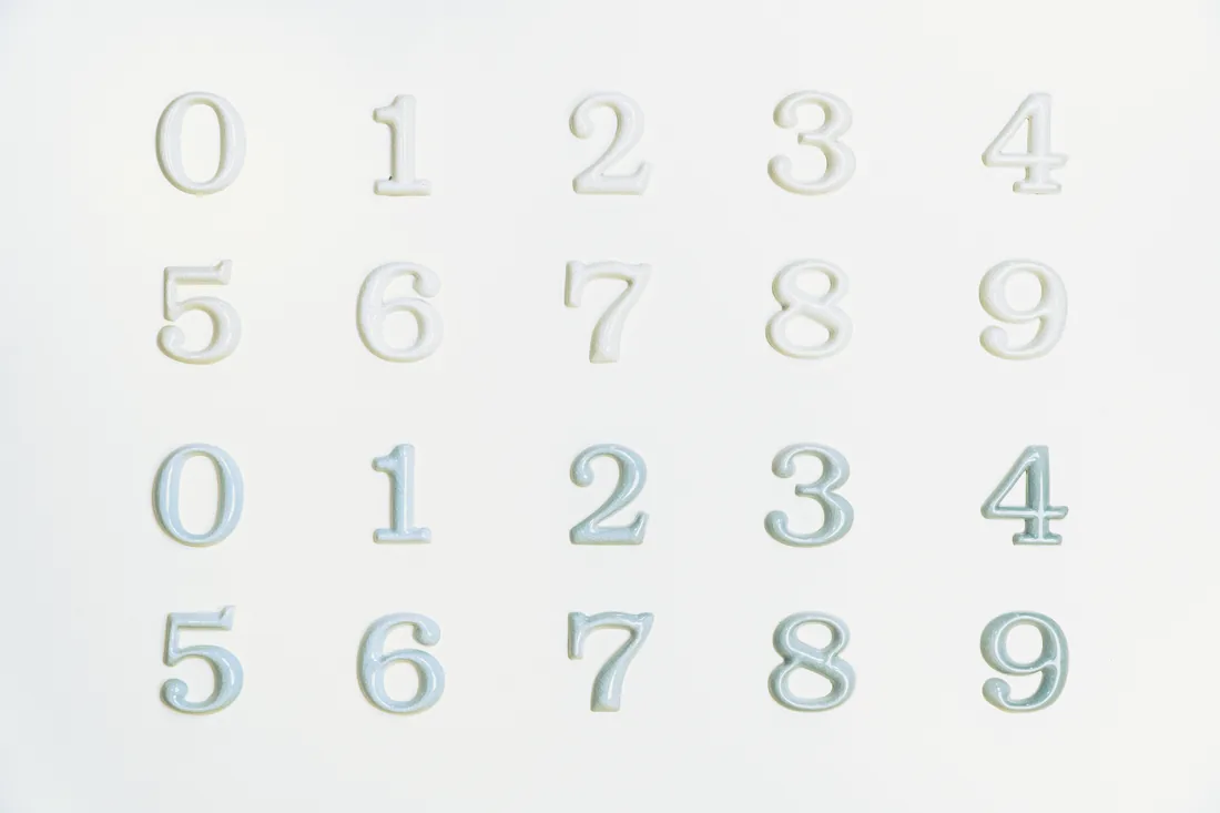 Glazed ceramic numerals 0-9 in white and pale blue