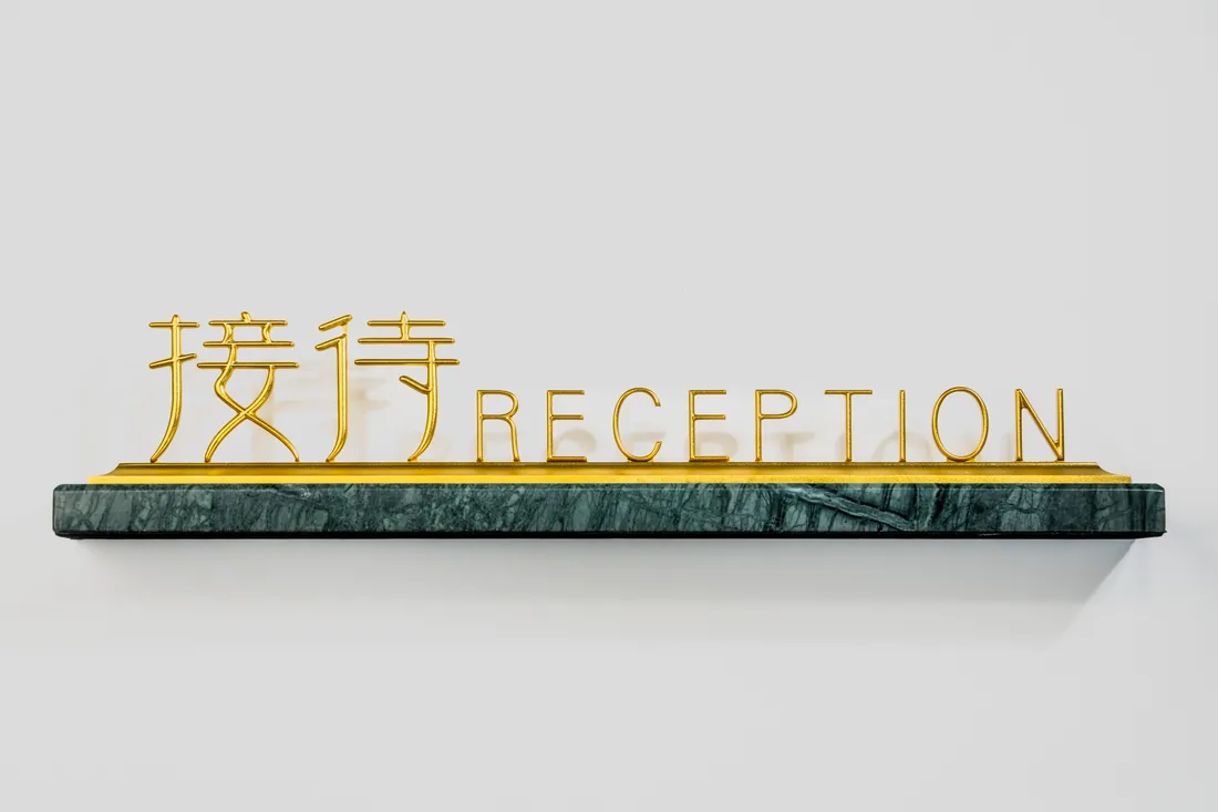 Gold cut-out RECEPTION letters on a green marble base