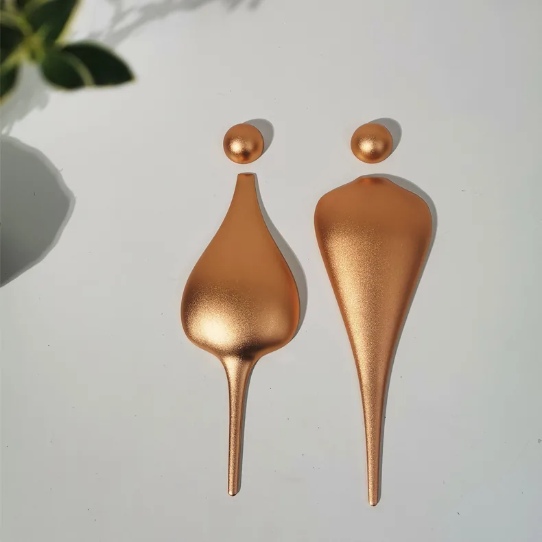 P001 CNC-carved aluminum restroom figures in matte copper finish
