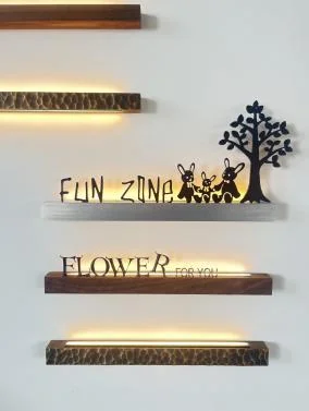 Catalog photograph of carved-aluminum bar-sign finish options including a dark wood-pattern bar beneath FLOWER lettering
