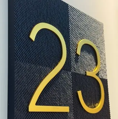 Close-up of raised black and gold hotel room number sign